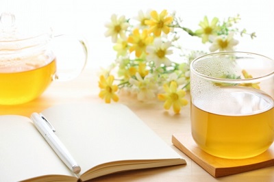 テーブルの上にある本と花とお茶